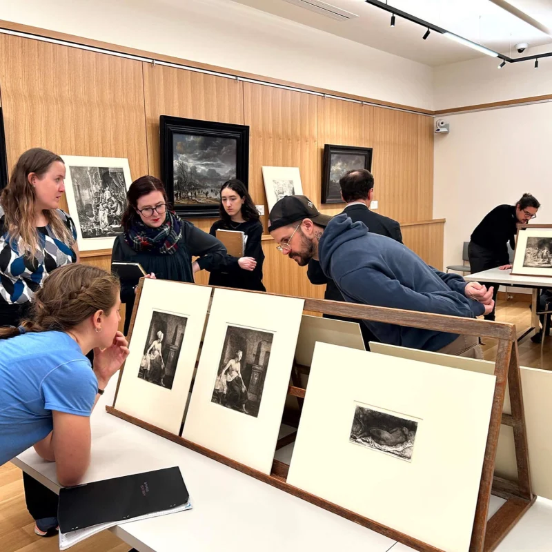 Visitors looking at prints in a museum gallery